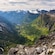 A deep, lush valley, surrounded on all sides by snow capped mountains